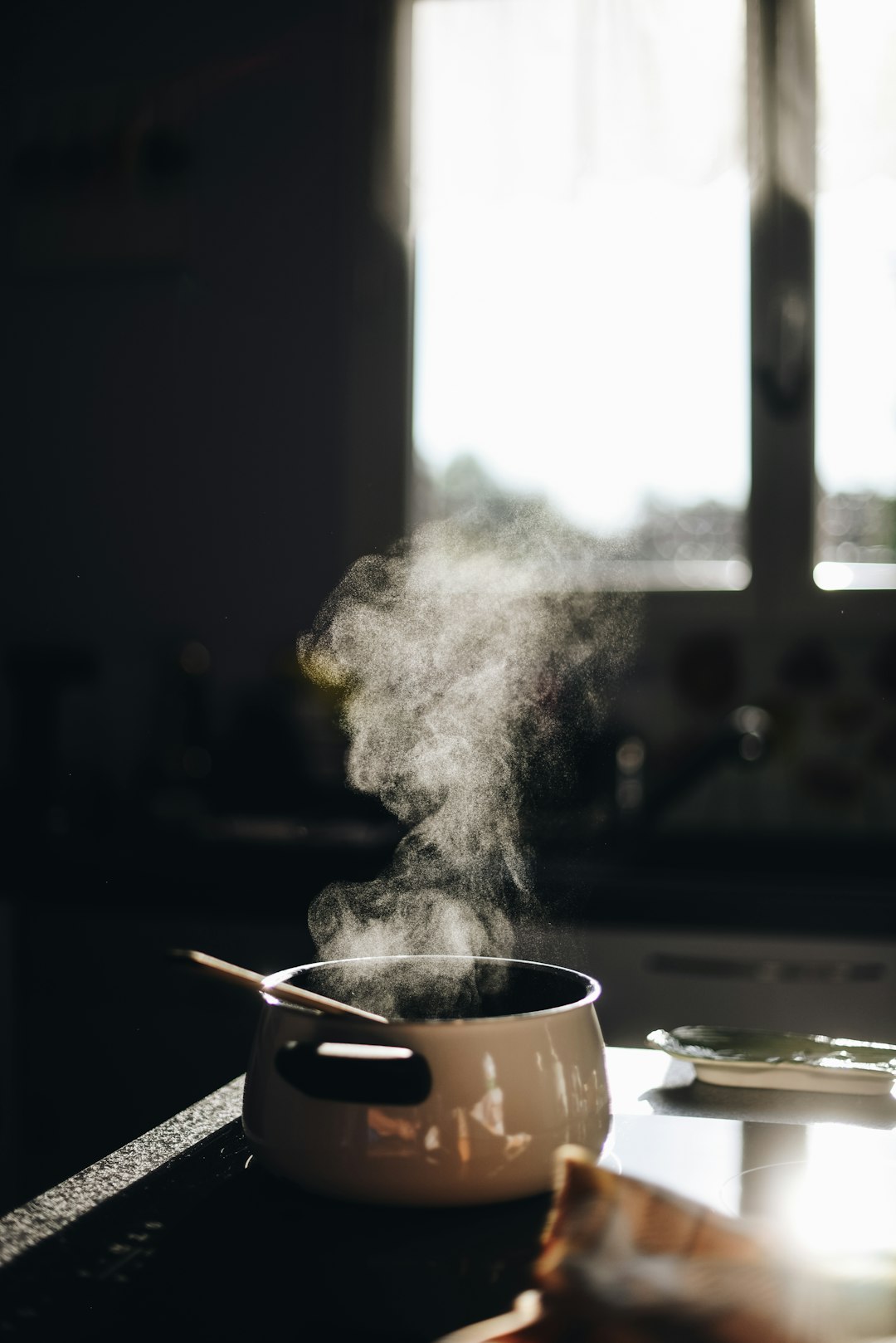 A pot steaming on a home kitchen stove